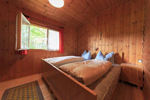 a bedroom with a bed in a wooden room at Aussersalfner Hütte in Schenna