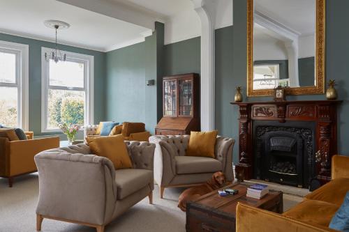a living room with couches and a fireplace and a mirror at Sentry Mead Hotel in Totland