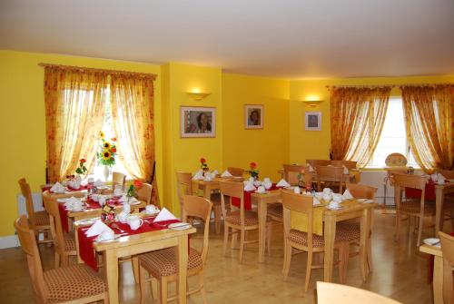 una sala da pranzo con tavoli, sedie e pareti gialle di Fanad House a Kilkenny