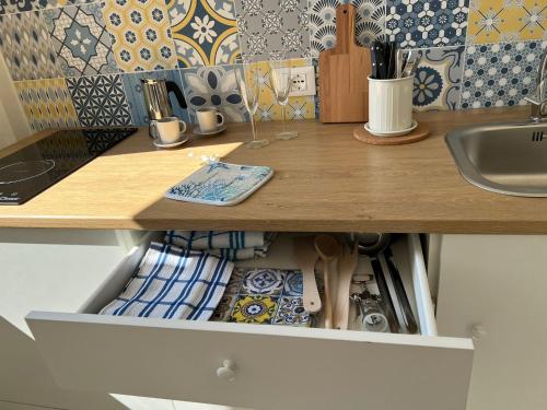a kitchen counter with a drawer filled with utensils at BlueSun Apartments in Leporano Marina