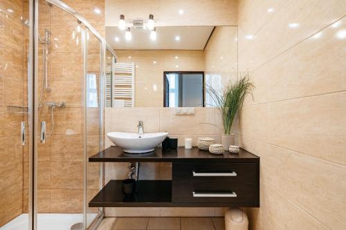 a bathroom with a sink and a shower at Honey Apartment by LoftAffair in Krakow