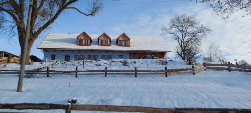 a house in the snow with a fence at Farma Hermína in Jilemnice