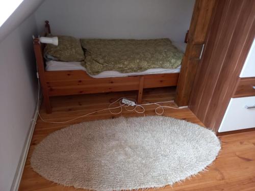 a small bedroom with a bed with a white rug at Farma Hermína in Jilemnice