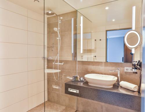 a bathroom with a sink and a shower at Holiday Inn - Villingen - Schwenningen by IHG in Villingen-Schwenningen