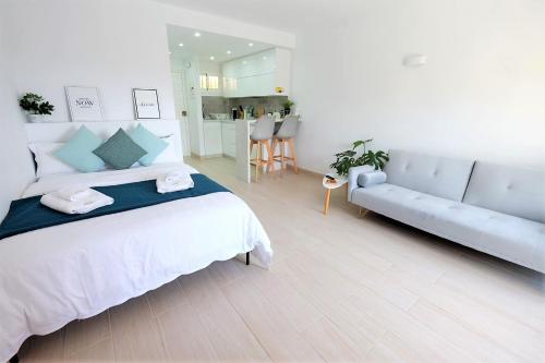 1 dormitorio blanco con 1 cama grande y 1 sofá en Benalmadena Jupiter - SunSea Apartments en Benalmádena