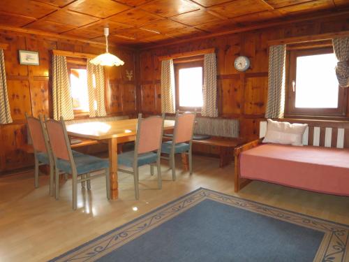 a dining room with a table and chairs and windows at Apartment Apart 14 by Interhome in Obergand