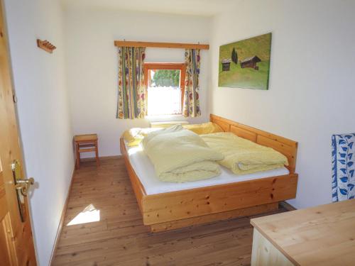 a bedroom with a wooden bed with a window at Apartment Apart 14 by Interhome in Obergand