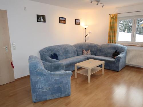 un soggiorno con divano blu e tavolo di Apartment Mühlenmichelshäusle by Interhome a Hinterzarten