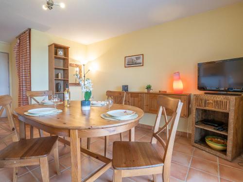 a dining room with a wooden table and a television at Apartment Catalona by Interhome in Saint-Cyprien-Plage