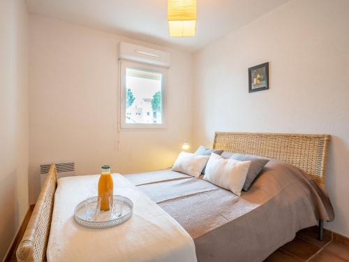 - une chambre avec un lit et une table avec une bouteille dans l'établissement Apartment Catalona by Interhome, à Saint Cyprien Plage