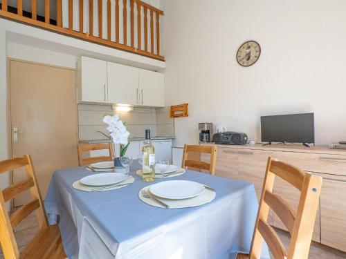 comedor con mesa con sillas y reloj en Holiday Home Thalassa-3 by Interhome, en Saint Cyprien Plage