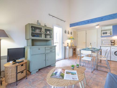 a kitchen with a tv and a table with a table at Holiday Home Les Marines du Roussillon by Interhome in Saint-Cyprien-Plage