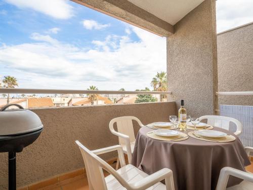 - une table avec des chaises blanches et une vue sur l'océan dans l'établissement Apartment Le Clos de St Cyprien-6 by Interhome, à Saint Cyprien Plage
