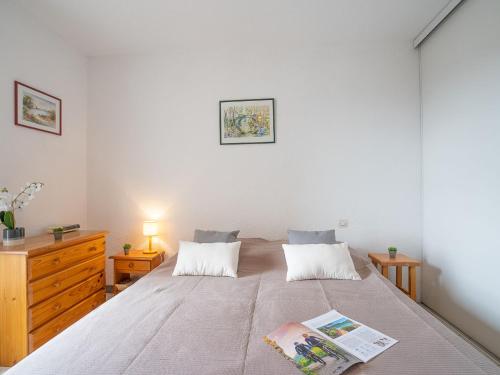 - une chambre avec un grand lit et une commode en bois dans l'établissement Apartment Le Clos de St Cyprien-6 by Interhome, à Saint Cyprien Plage