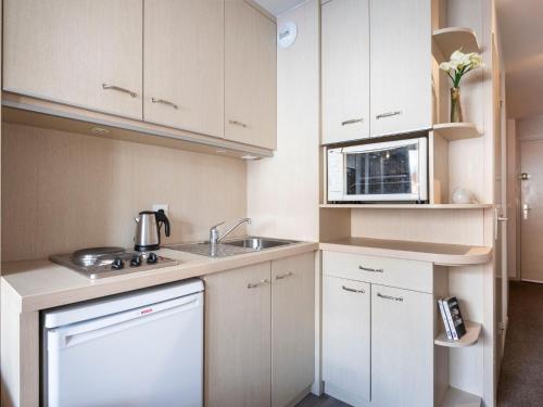 une petite cuisine avec un évier et un micro-ondes dans l'établissement Apartment Vanoise 167 by Interhome, à Val Thorens