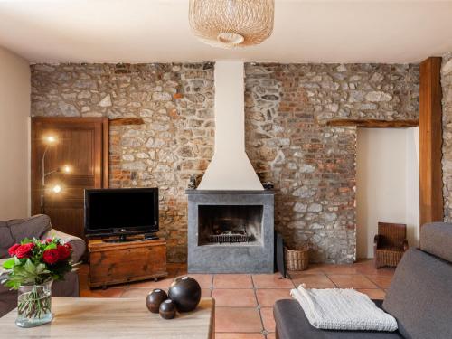 sala de estar con pared de piedra y chimenea en Holiday Home La Bastide by Interhome en Thy-le-Bauduin