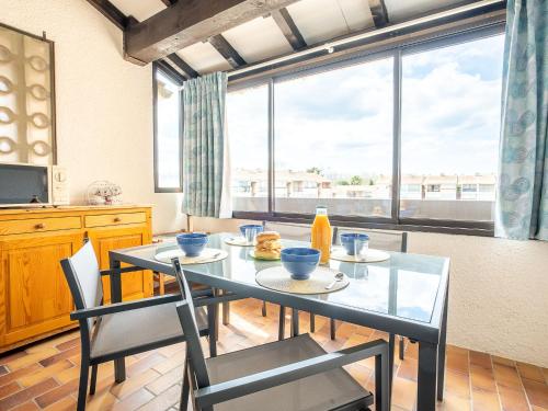 une salle à manger avec une table et des chaises et une grande fenêtre dans l'établissement Apartment Port au Prince by Interhome, à Saint Cyprien Plage