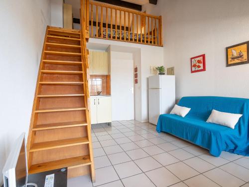 - un salon avec un canapé bleu et un escalier en bois dans l'établissement Apartment Port au Prince by Interhome, à Saint Cyprien Plage