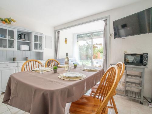 une cuisine avec une table, des chaises et un tissu de table dans l'établissement Apartment Les Mas de La Mer-1 by Interhome, à Saint Cyprien Plage