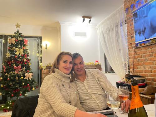 红湖Casa Bicăjeanului - Lacu Roșu的一男一女坐在桌边，手捧酒杯