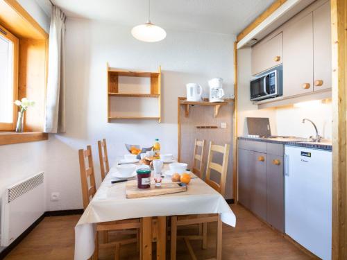 une cuisine avec une table et un chiffon de table blanc dans l'établissement Apartment Arcelle 308 by Interhome, à Val Thorens