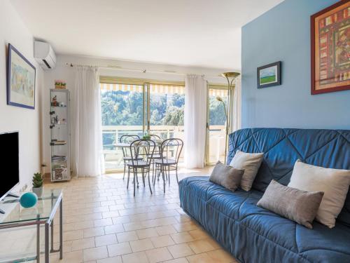 un salon avec un canapé bleu et une table dans l'établissement Apartment Domaine du Clairfontaine by Interhome, à Nice