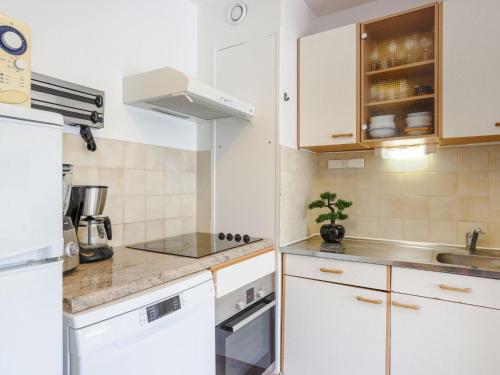 une cuisine avec des armoires blanches et un évier dans l'établissement Apartment Domaine du Clairfontaine by Interhome, à Nice