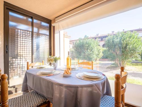 une salle à manger avec une table et une grande fenêtre dans l'établissement Studio Les Bastides de Grand Stade-1 by Interhome, à Saint Cyprien Plage