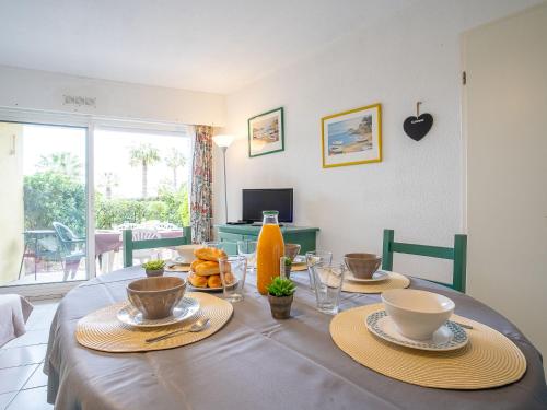 une table de salle à manger avec des assiettes de nourriture dessus dans l'établissement Apartment Les Goelettes-8 by Interhome, à Saint Cyprien Plage