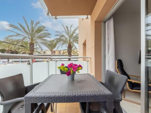 a table with chairs and a vase of flowers on a balcony at Apartment Terecel Salou-1 by Interhome in Salou