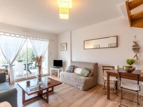 a living room with a couch and a table at Holiday Home Le Hameau des Pêcheurs 1 by Interhome in Mimizan-Plage