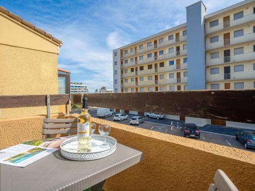 - une bouteille de vin et des verres sur une table sur un balcon dans l'établissement Apartment Les Mas de La Mer-6 by Interhome, à Saint Cyprien Plage