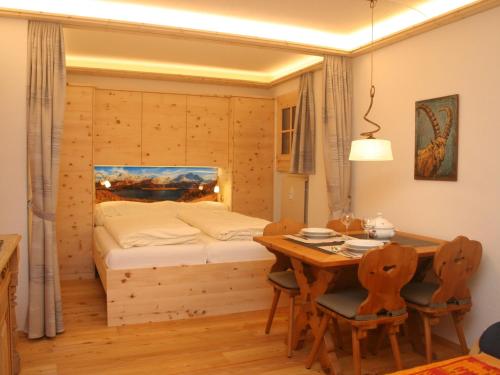Schlafzimmer mit einem Bett und einem Tisch mit Stühlen in der Unterkunft Apartment Chesa Alvetern 5 by Interhome in Sils Maria
