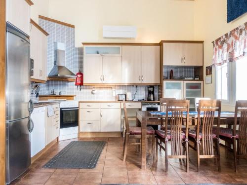 レヴィにあるHoliday Home Levijoutsen by Interhomeのキッチン(テーブル、椅子、冷蔵庫付)
