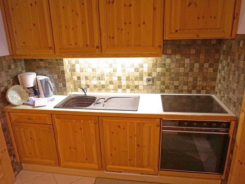 eine Küche mit Holzschränken und einem Waschbecken in der Unterkunft Apartment Birkenwald-2 by Interhome in Seefeld in Tirol