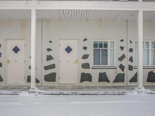 a wall with three doors and a window on a building at Holiday Home Vaeltajankulma huoneisto 3 by Interhome in Ylläs