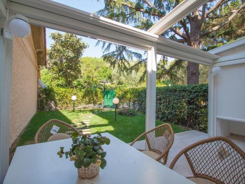 a patio with a white table and chairs and a window at Holiday Home Red Stones by Interhome in Punta Ala