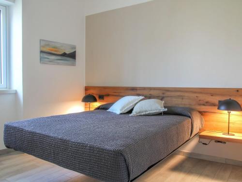 a bedroom with a large bed with two lamps at Apartment La Maison Blanche-1 by Interhome in Brenzone sul Garda