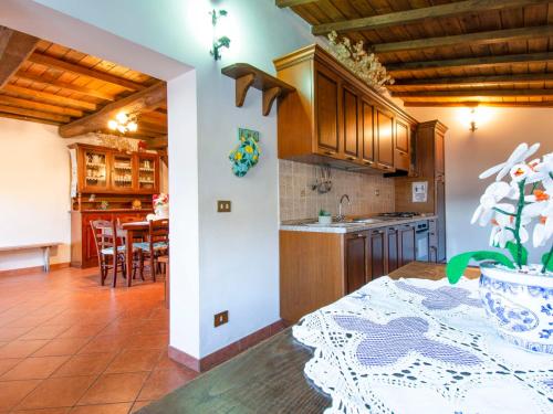 a kitchen with wooden cabinets and a table with a vase at Holiday Home Paradiso II by Interhome in Bolognana