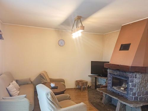 ein Wohnzimmer mit einem Kamin und einem TV in der Unterkunft Holiday Home Lgota by Interhome in Witanowice