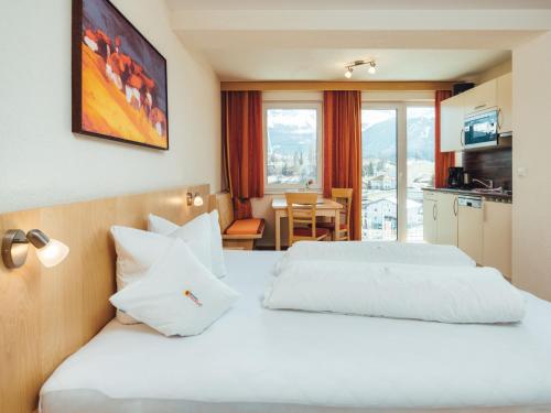 um quarto de hotel com uma cama branca e uma mesa em Apartment Ladis-8 by Interhome em Ladis