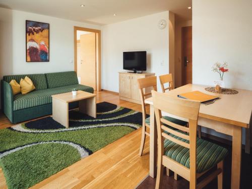 ein Wohnzimmer mit einem grünen Sofa und einem Tisch in der Unterkunft Apartment Ladis-1 by Interhome in Ladis