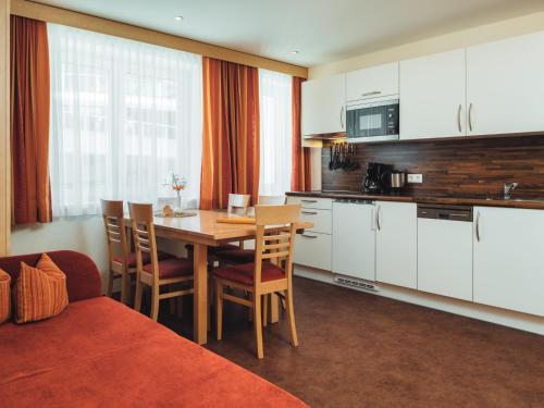 eine Küche und ein Esszimmer mit einem Tisch und Stühlen in der Unterkunft Apartment Ladis-2 by Interhome in Ladis