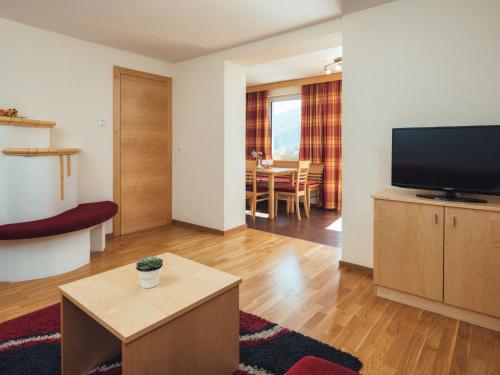ラディスにあるApartment Ladis-5 by Interhomeのテレビとテーブルのあるリビングルーム