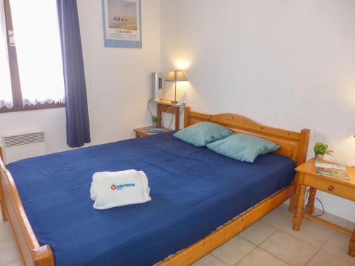 a bedroom with a blue bed with a white towel on it at Holiday Home Le Mas des Calanques by Interhome in Saint-Aygulf