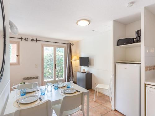 une cuisine et une salle à manger avec une table et un réfrigérateur dans l'établissement Apartment Cap Négre - Domaine de la Pinède-4 by Interhome, à Aigue-Belle