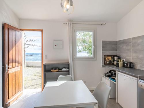 a kitchen with a table and chairs and a window at Holiday Home Marine di Manichinu - SOZ400 by Interhome in Sari Solenzara