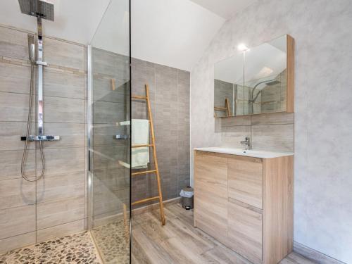a bathroom with a shower and a sink and a mirror at Chalet Le Petit Chalet by Interhome in La Haye-dʼEctot