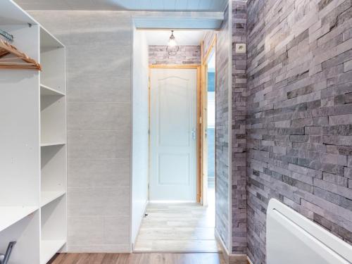 a hallway with a brick wall and a white door at Chalet Le Petit Chalet by Interhome in La Haye-dʼEctot