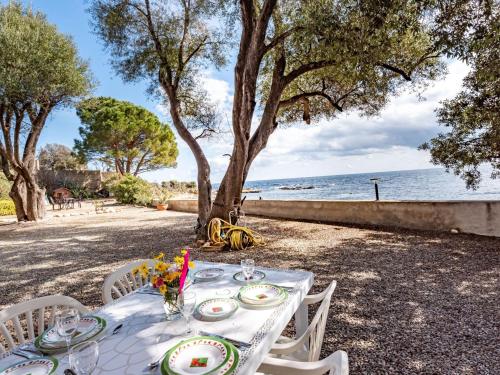 a table with plates on it next to the ocean at Holiday Home Scorpina by Interhome in Sari Solenzara